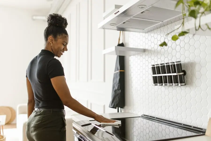 Person wiping down an electric stove top