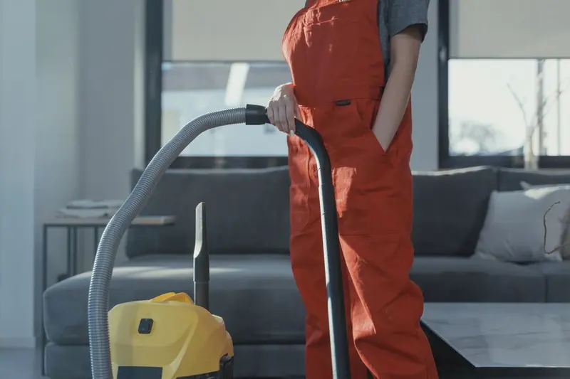 Person using a vacuum cleaner on tiled flooring