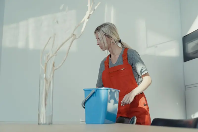 Cleaner in orange jumpsuit at work
