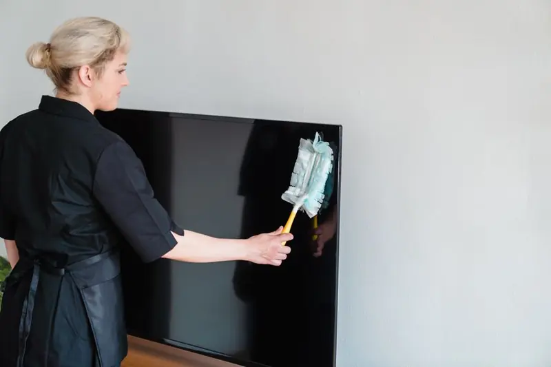 Person dusting a surface with a cloth
