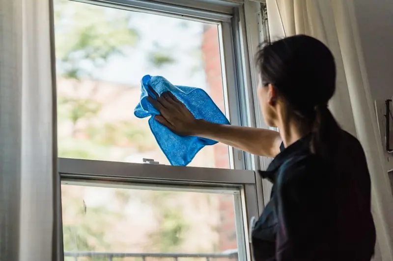 Person cleaning a window with a cloth