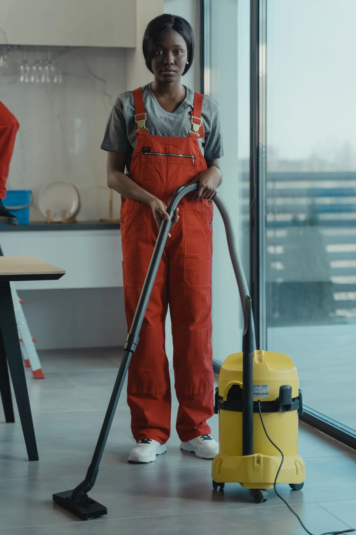 Dosherm cleaning technician using professional equipment in a bright modern home