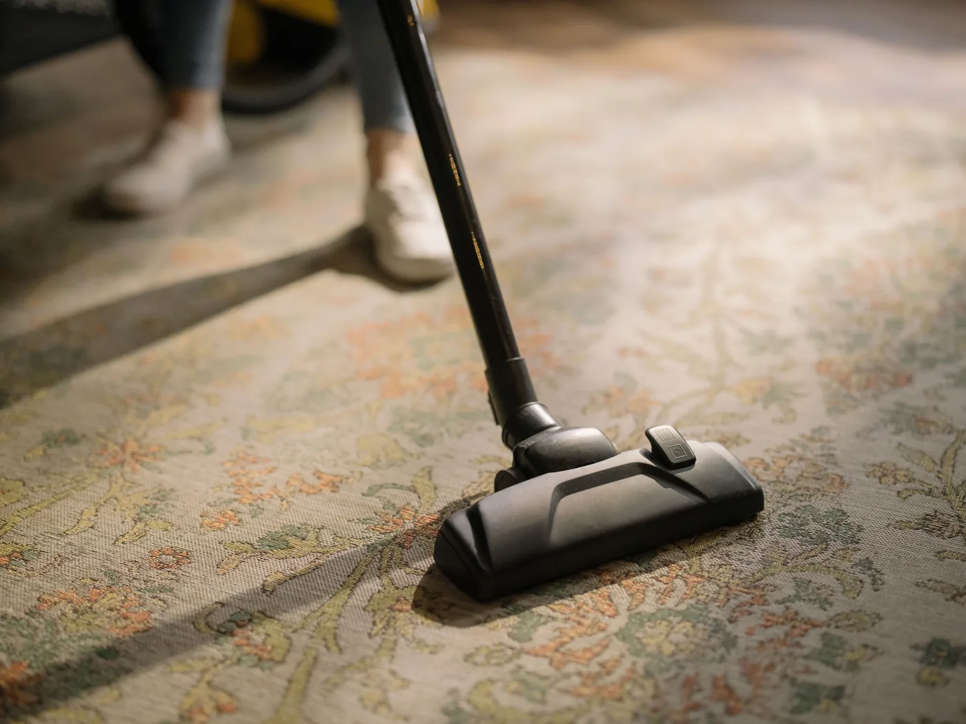 Vacuum cleaner head being used on a patterned area rug