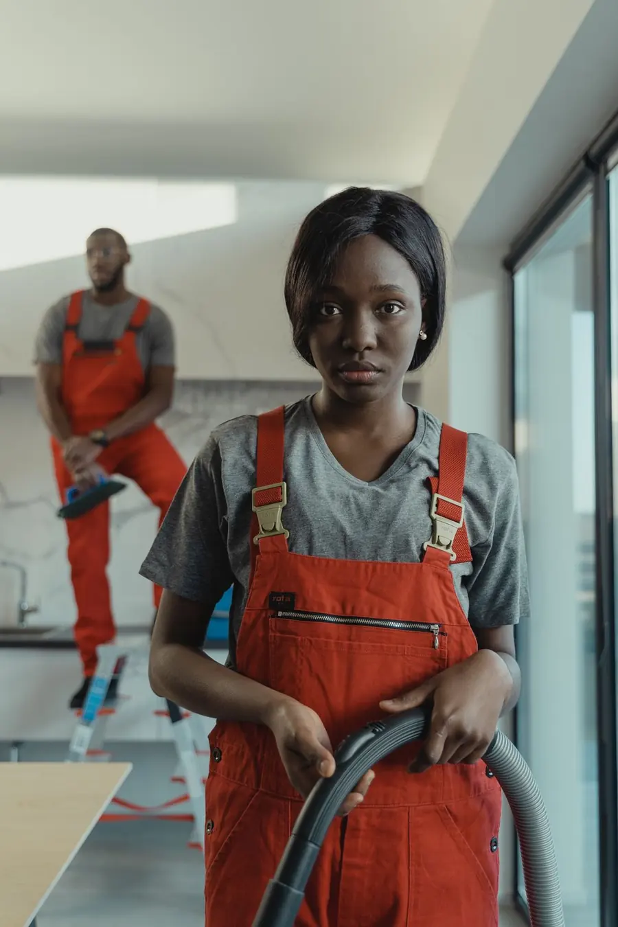 Cleaner in orange overalls deep cleaning a residential interior