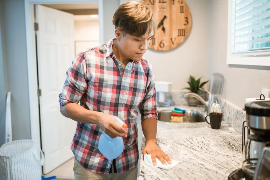 Cleaner wiping down a kitchen counter surface